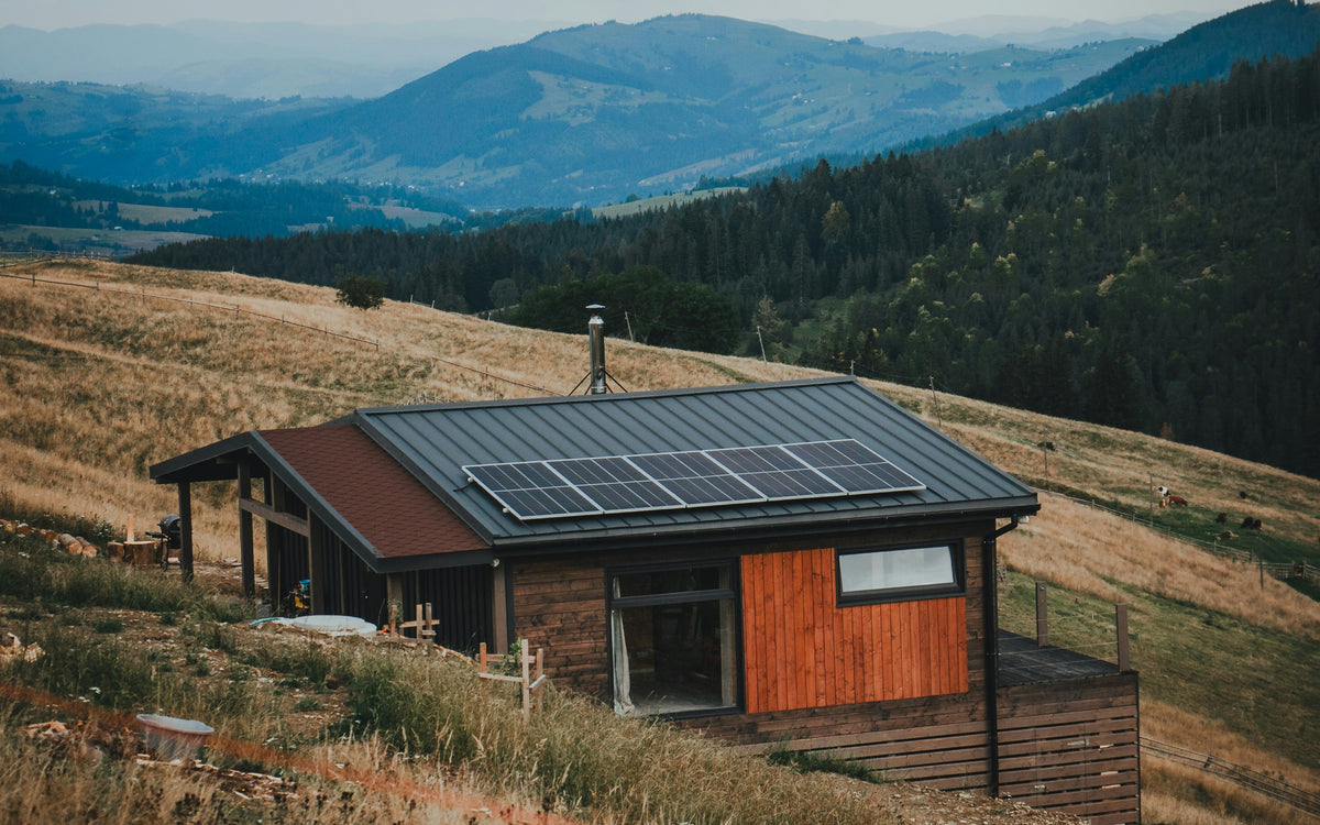 Small hillside cabin with solar panels on the roof